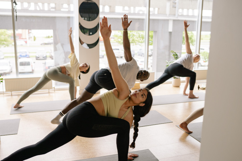 Students in a yoga hall preforming a twisting lunge